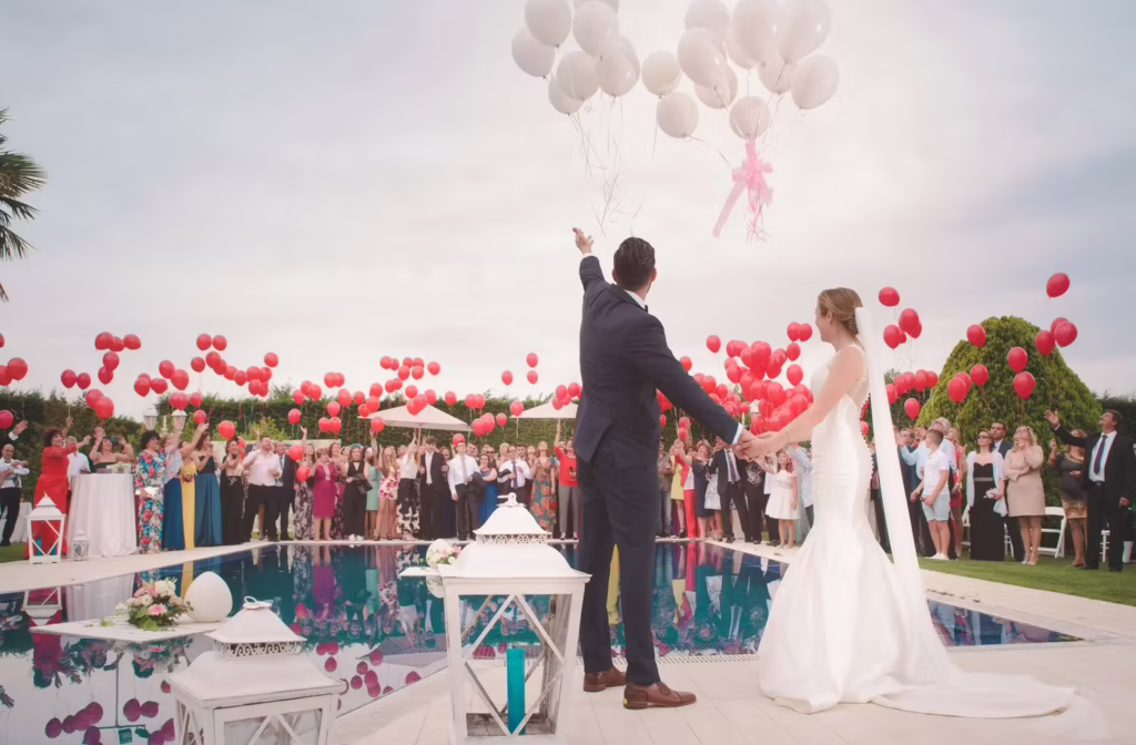 Brautpaar bei einer freien Trauung im Freien mit weißen Luftballons