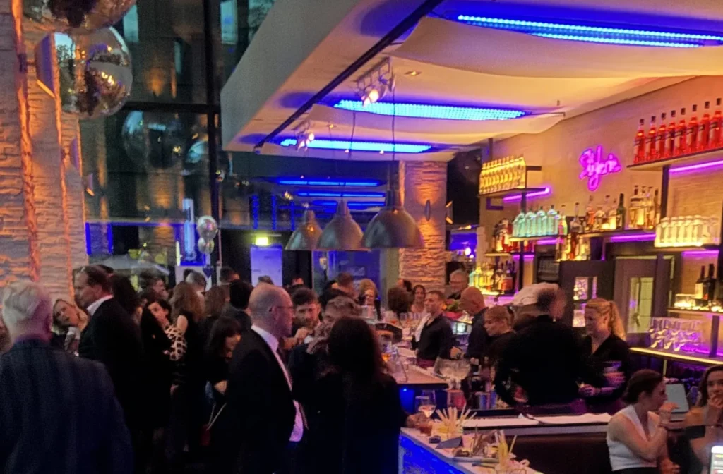 DJ Firmenfeier München – Gäste an der beleuchteten Bar bei einem Firmenevent