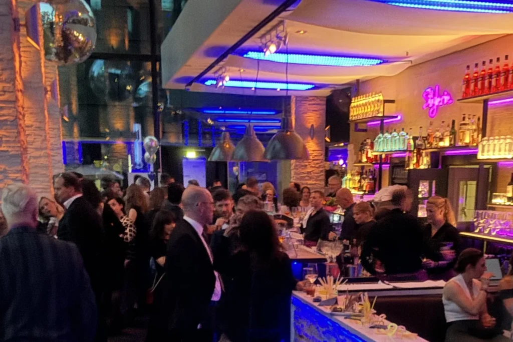 DJ Firmenfeier München – Gäste an der beleuchteten Bar bei einem Firmenevent
